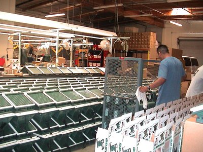 A Man In A Factory Surrounded By Numerous Massager Boxes