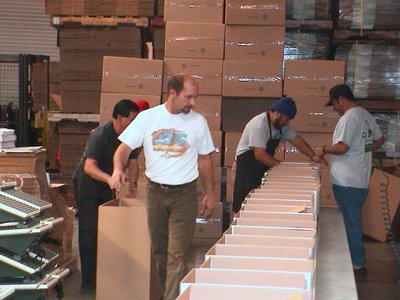 Several Men In A Warehouse Diligently Handling Boxes